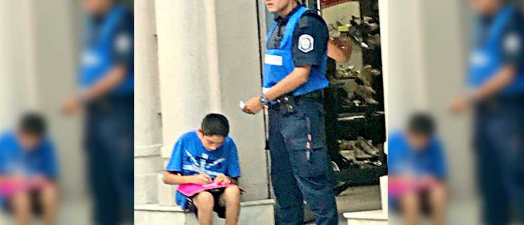Una ejemplar actitud: un policía ayuda a estudiar a un chico en la calle