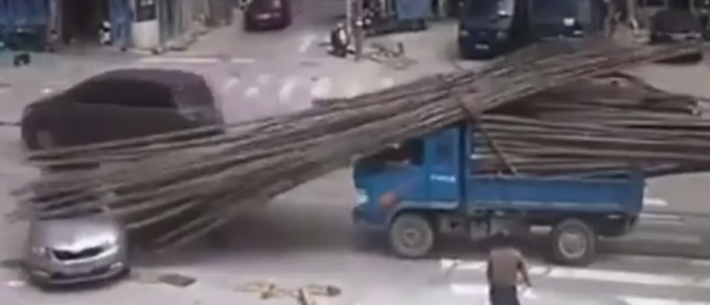 Video: una carga de troncos se derrumba sobre un auto 
